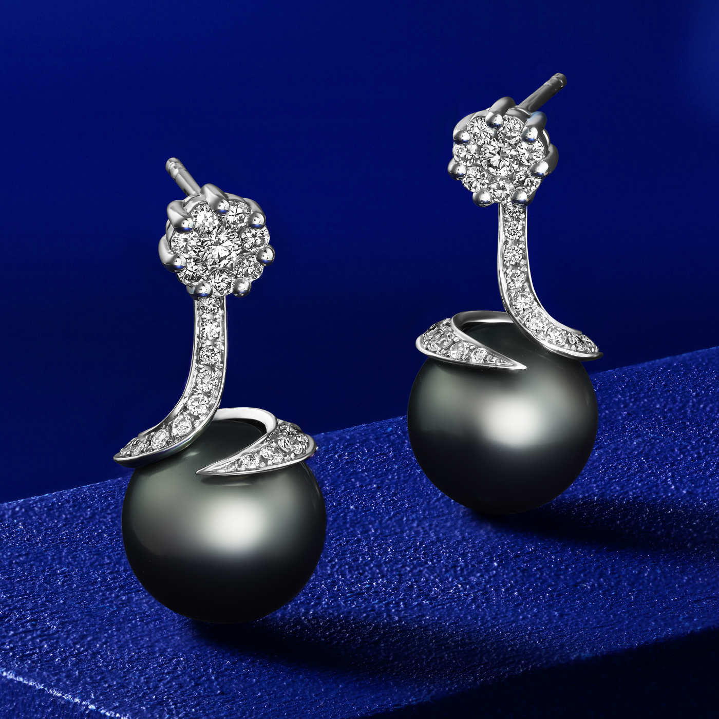 Spirale earrings with natural tahitian pearl with pave set diamonds in spirale design ,designed by carati jewelry montreal canada 18 k 14 k in blue backround