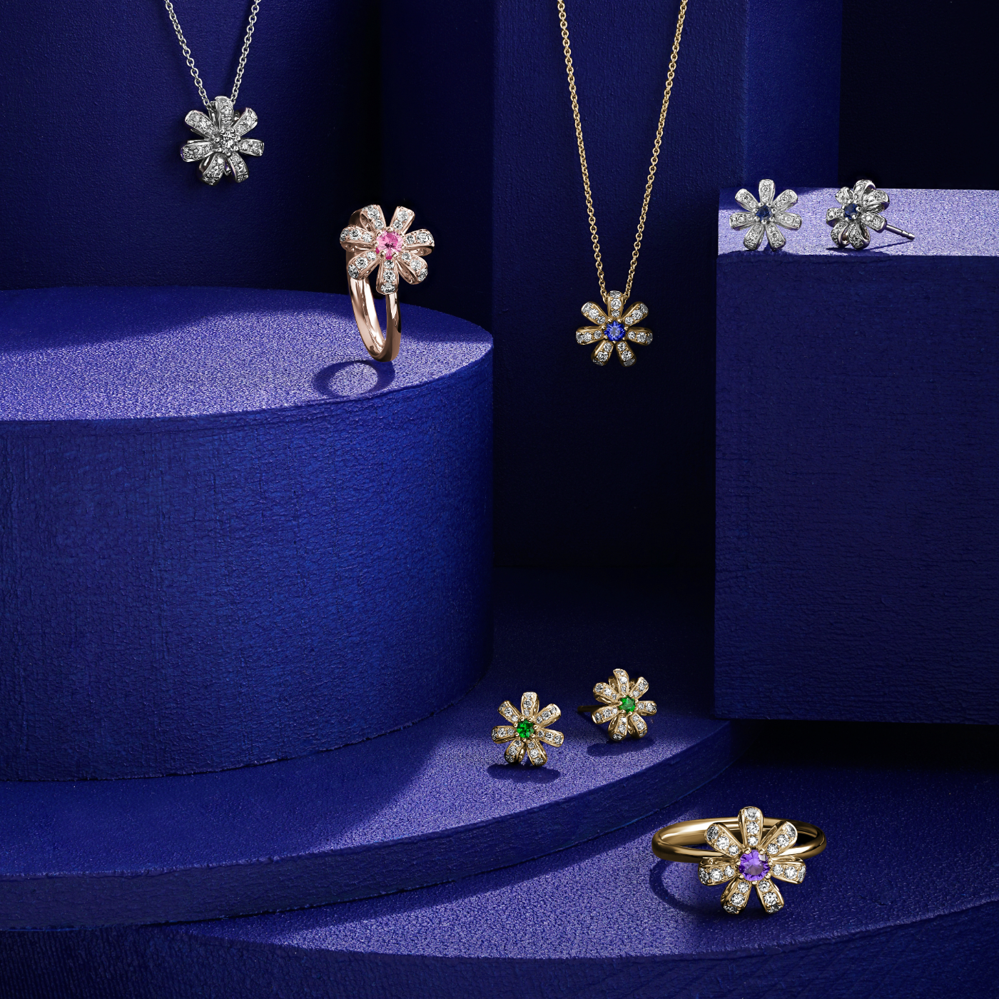 A pair of Fiora earrings with natural royal blue sapphires centers and encrusted with diamonds set in pave designed by carati jewelry montreal canada 18k 14 k in blue backround and the whole collection