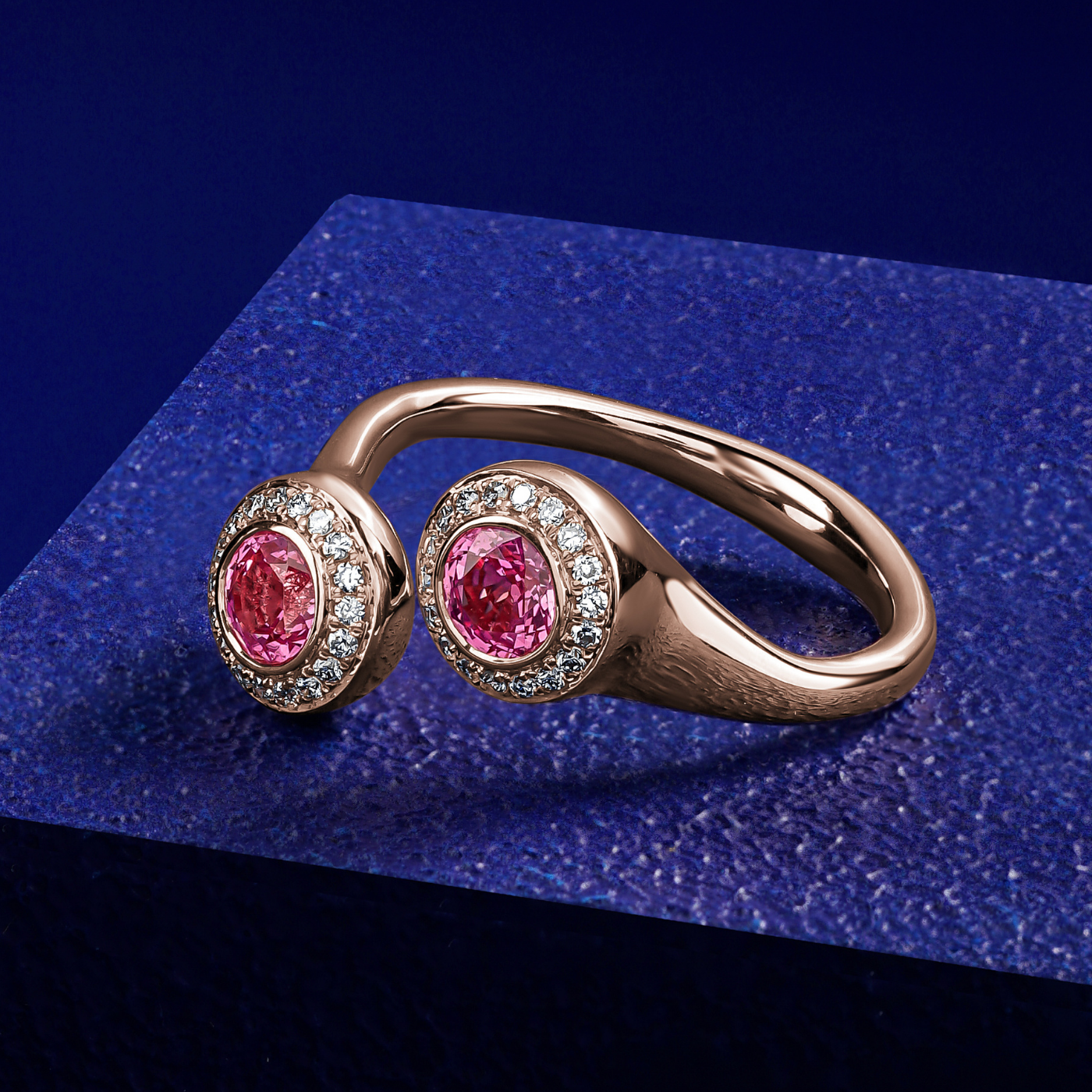 Toi et moi reimagined with 2 pink sapphires surrounded by pave set diamonds designed by carati jewelry montreal canada 14 k 18 k in blue backround