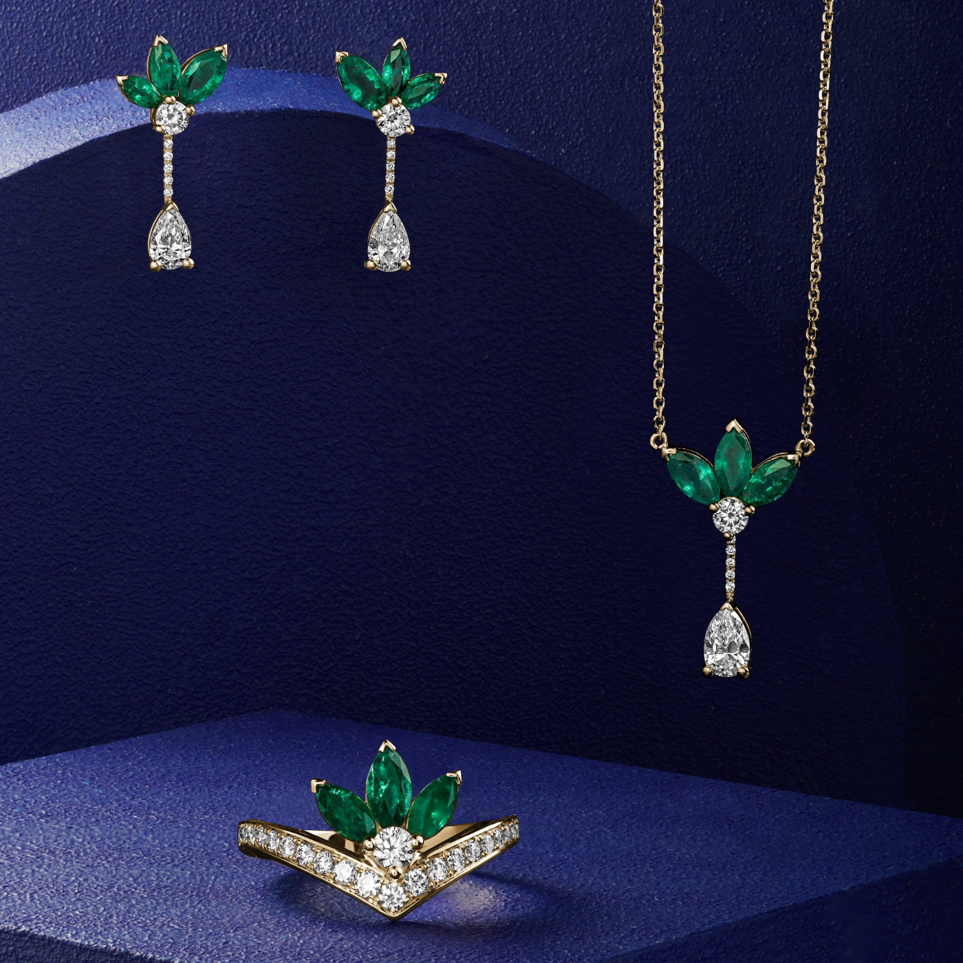 Majesty Pendant with marquise Emeralds and a pear diamond is designed by carati jewelry in Montreal Canada in 14k 18k in blue backround with the whole collection