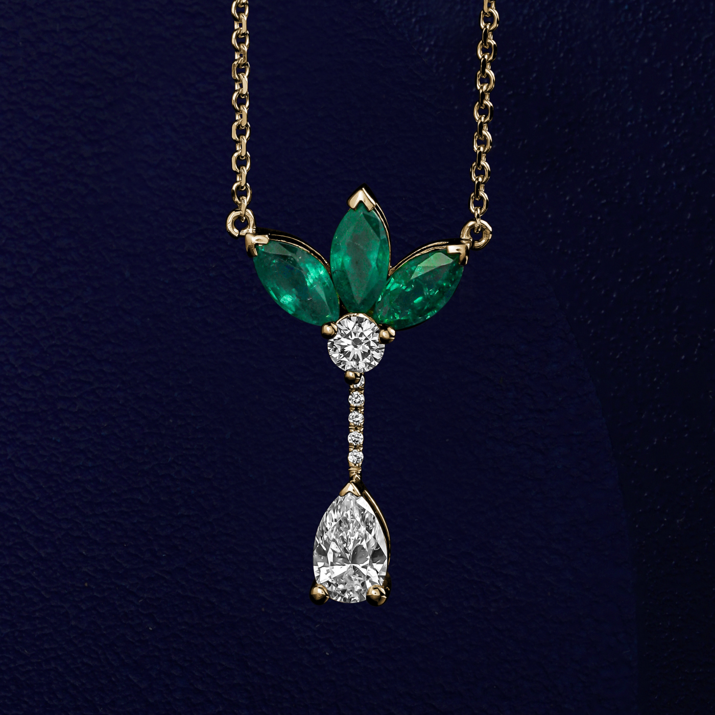 Majesty Pendant with marquise Emeralds and a pear diamond is designed by carati jewelry in Montreal Canada in 14k 18k in blue backround and zoomed