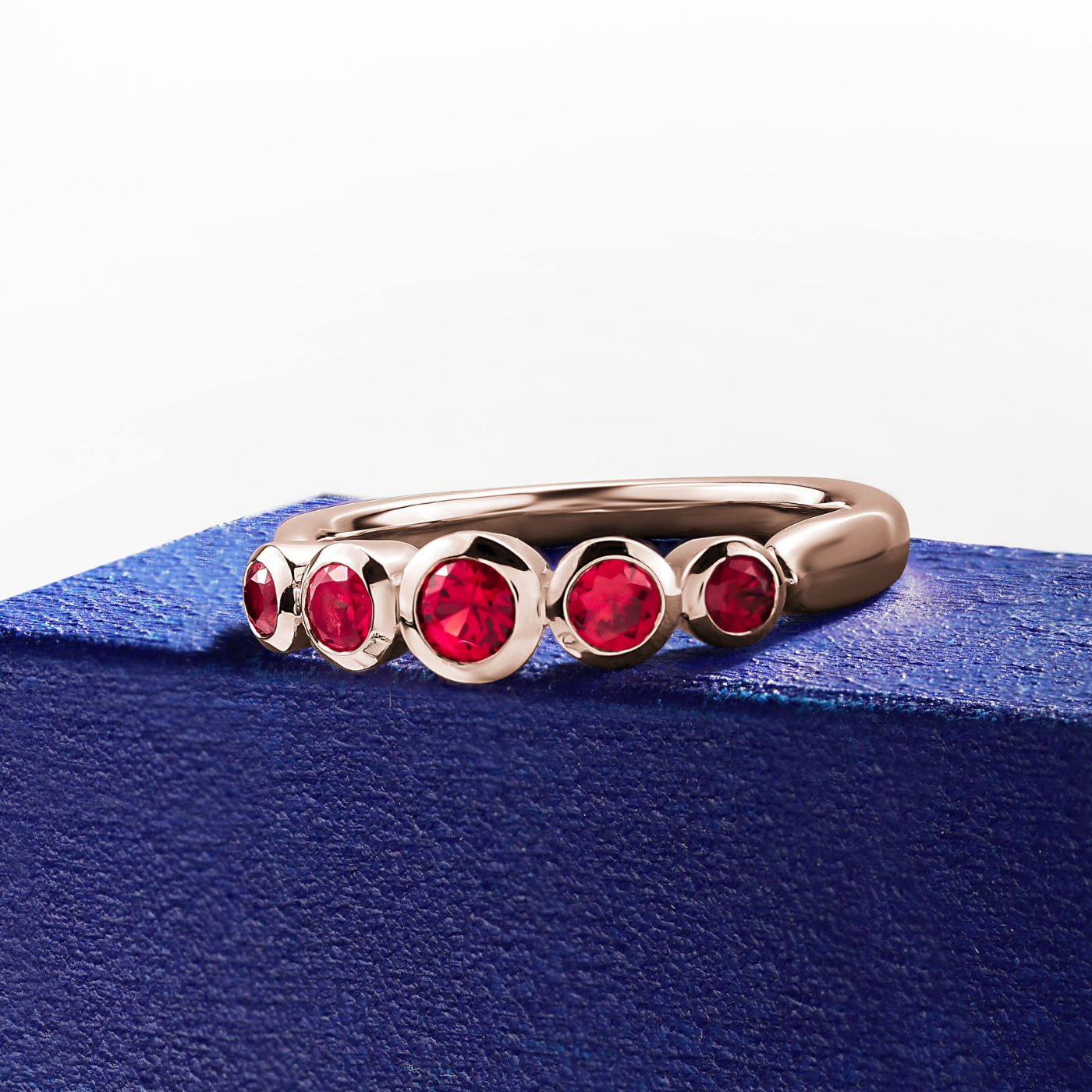 Aria ring with 5 bezels set in rubys designed by carati jewelry montreal canada 18k 14 k in blue backround