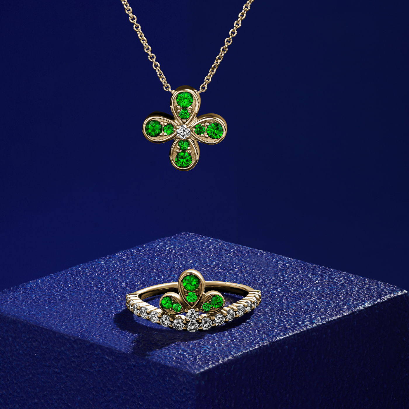 Bloom ring set with tzavorites and diamonds going half way designined by carati jewelry montreal canada 18 k 14 k in blue backround with the pendant