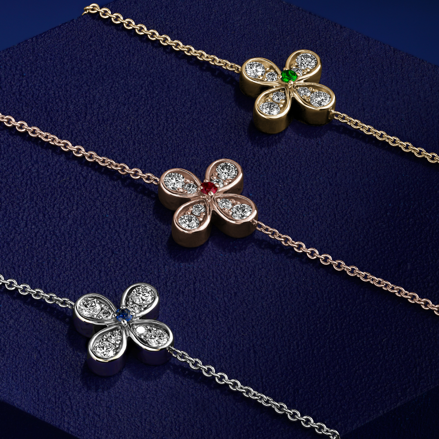 in blue backround and top of a piece Bloom bracelets with a floral charm featuring a blue sapphire center and small diamond accents designed by carati jewelry in montreal canada in 18 k 14 k