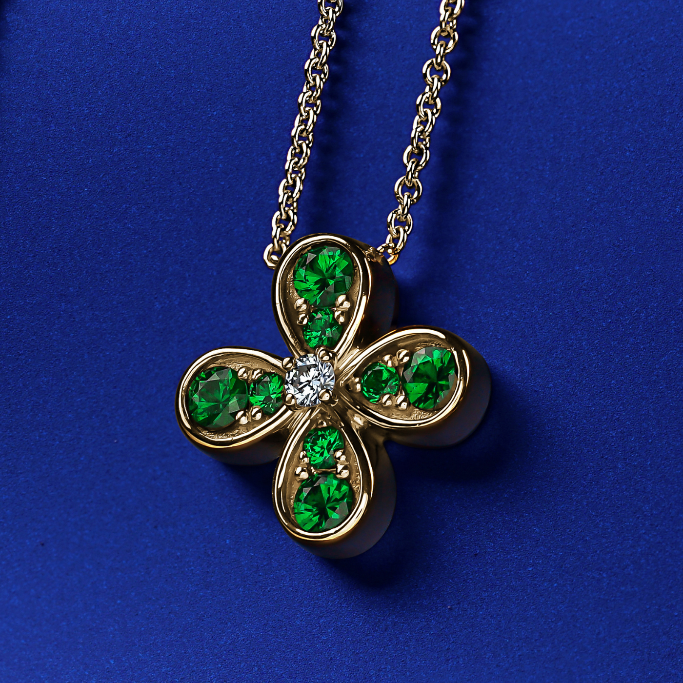 Bloom pendant set with tsavorites and a diamond in the middle designed by carati jewelry montreal canada 18k 14 k in zoom and blue backround