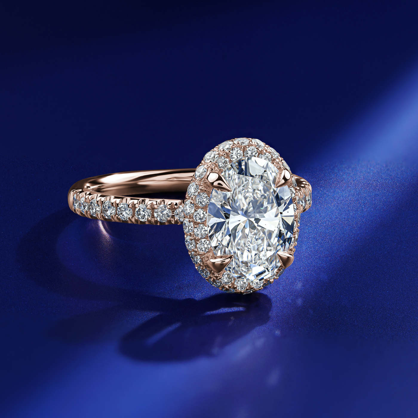Eterno oval engagement ring set with pave on the top and band in a sophisticated spark designed by carati jewelry in montreal canada in 18 k 14 k in blue backround zoom