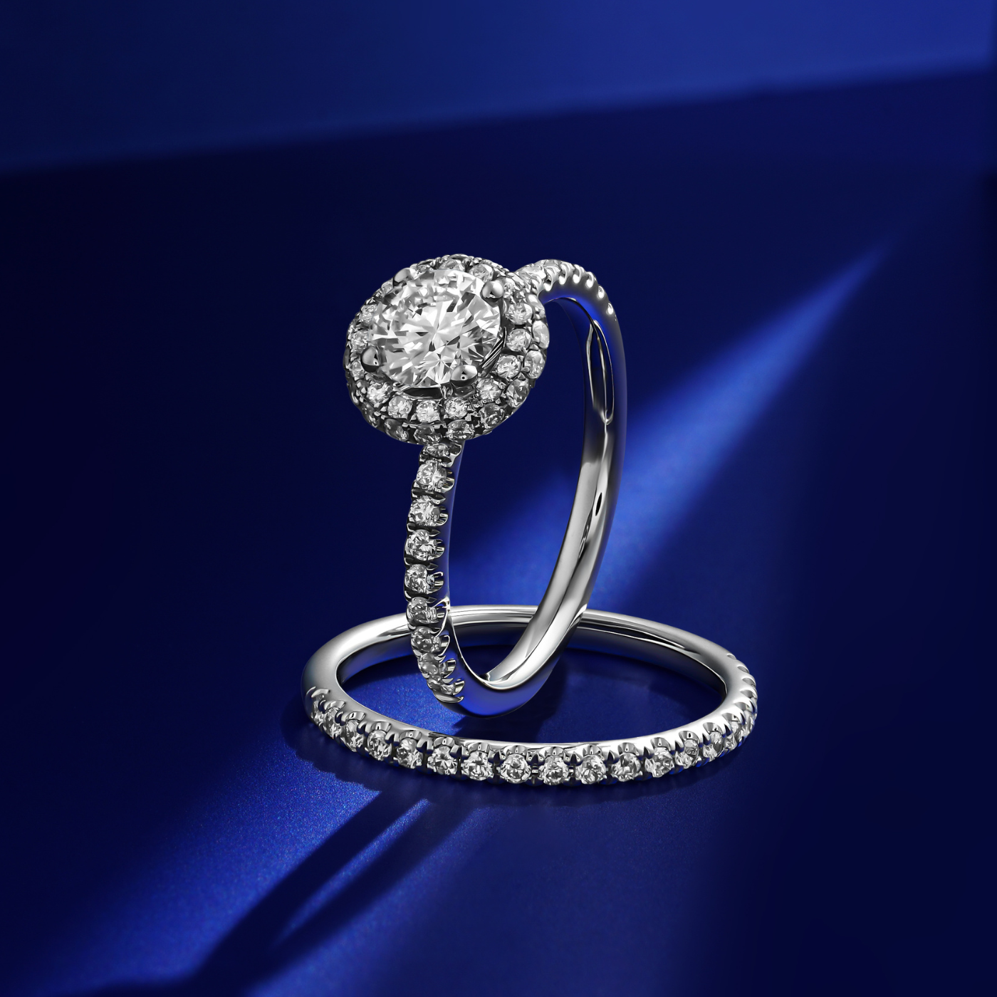 in blue backround with matching Destino Round Engagement Ring with a halo of diamonds around the central diamond, set in a white gold band designed by carati jewelry in montreal canada in 18 k 14 k