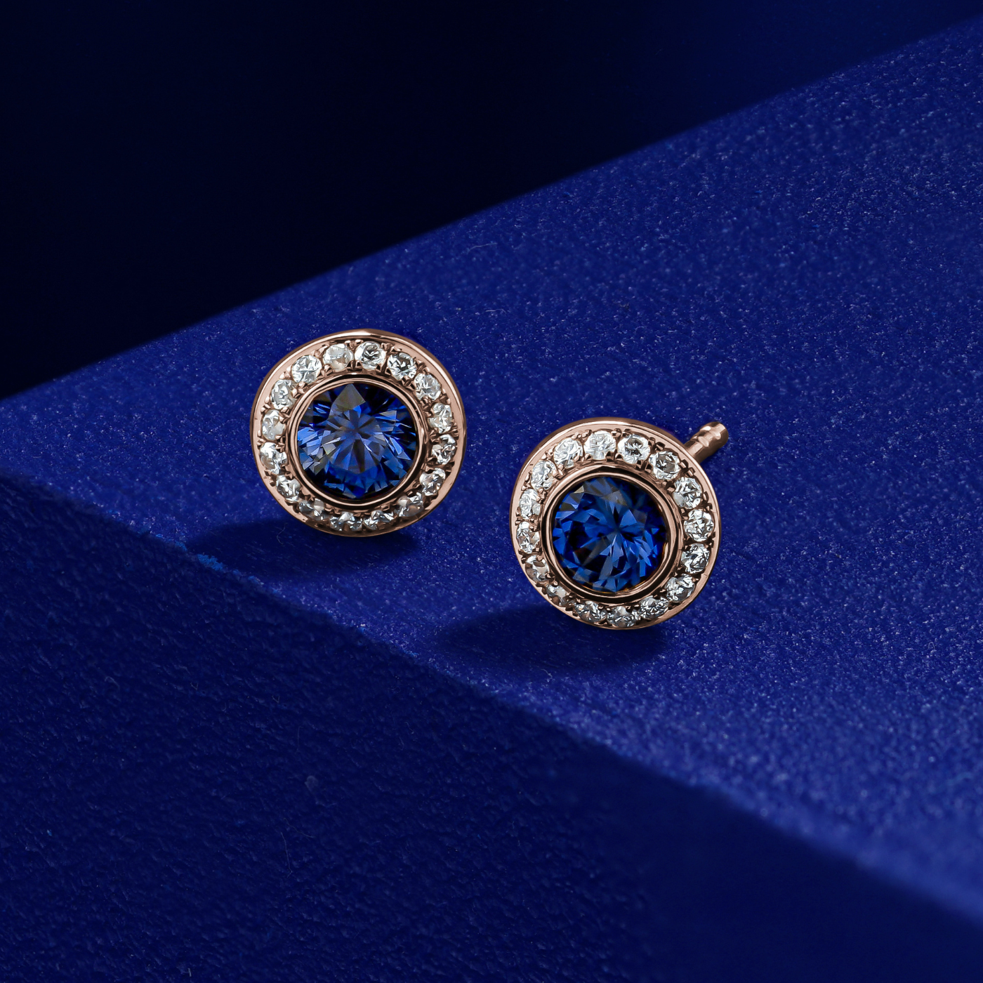 Royal Harmony earring Centered Around a stunning royal blue sapphire set all around pave in diamonds designed by carati jewelry in montreal canada in 14 k 18 k in blue backround in zoom