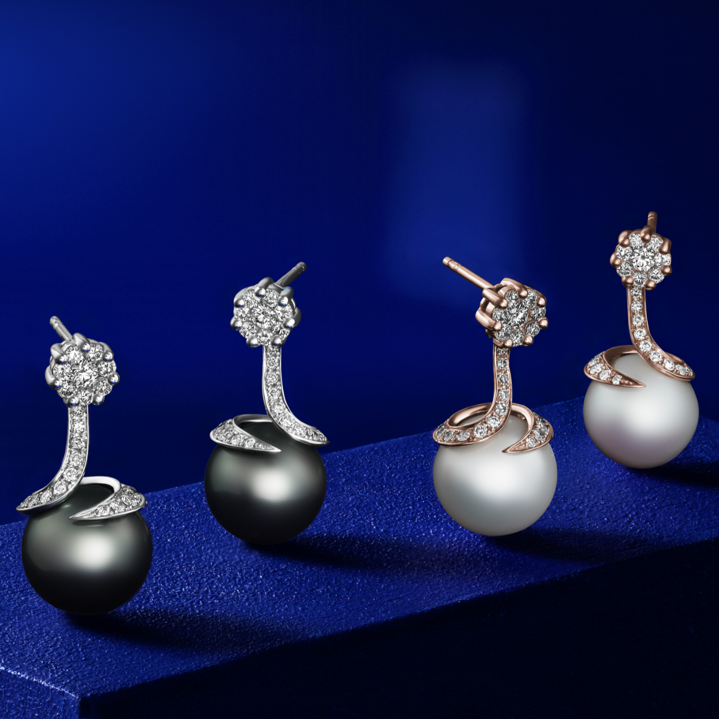 Spirale earrings with natural south sea pearl with pave set diamonds in spirale design ,designed by carati jewelry montreal canada 18 k 14 k in blue backround with the tahitian peral earring
