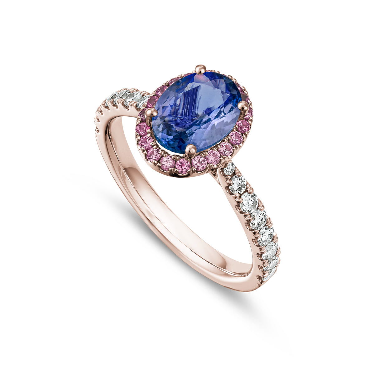 An engagement ring featuring an oval cut tanzanite center stone with a halo of pink sapphires and diamonds around it, set in a white gold band designed by carati jewelry in montreal canada in 18 k 14 k