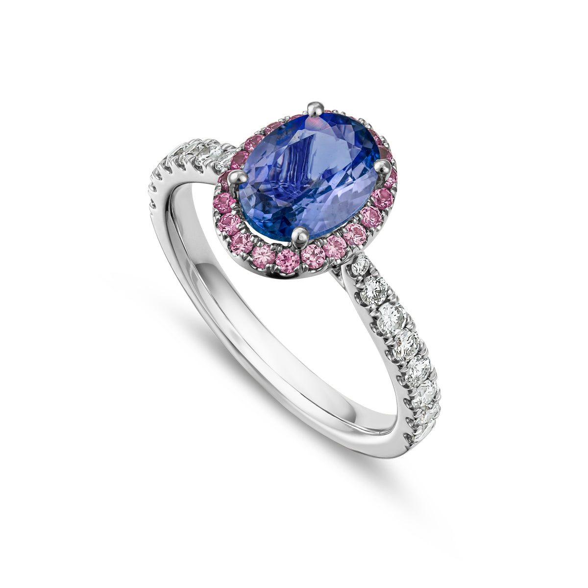 An engagement ring featuring an oval cut tanzanite center stone with a halo of pink sapphires and diamonds around it, set in a white gold band designed by carati jewelry in montreal canada in 18 k 14 k