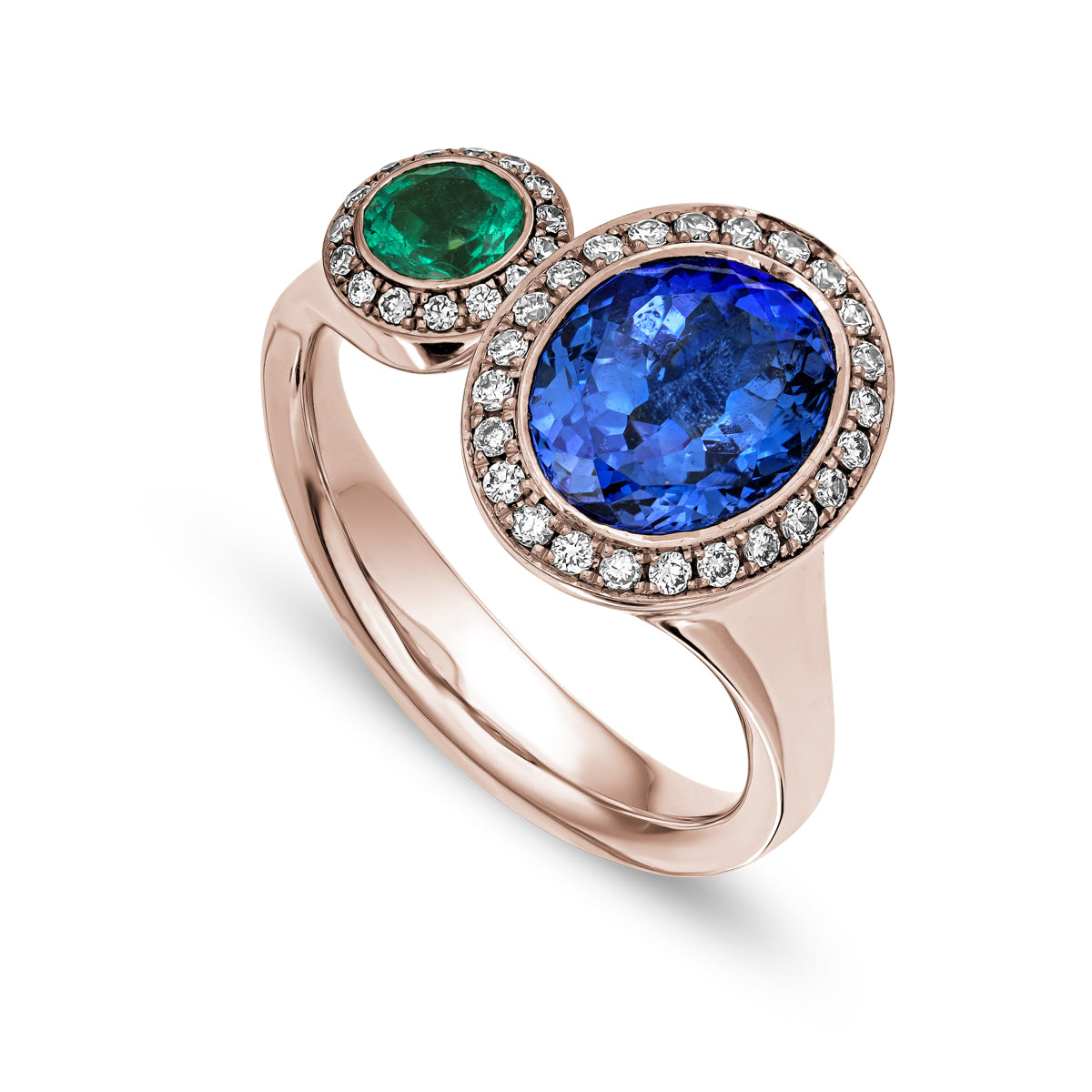 Toi et moi ring featuring an oval-shaped tanzanite and a round emerald surrounded by smaller diamonds sophisticated spark designed by carati jewelry in montreal canada in 18 k 14 k