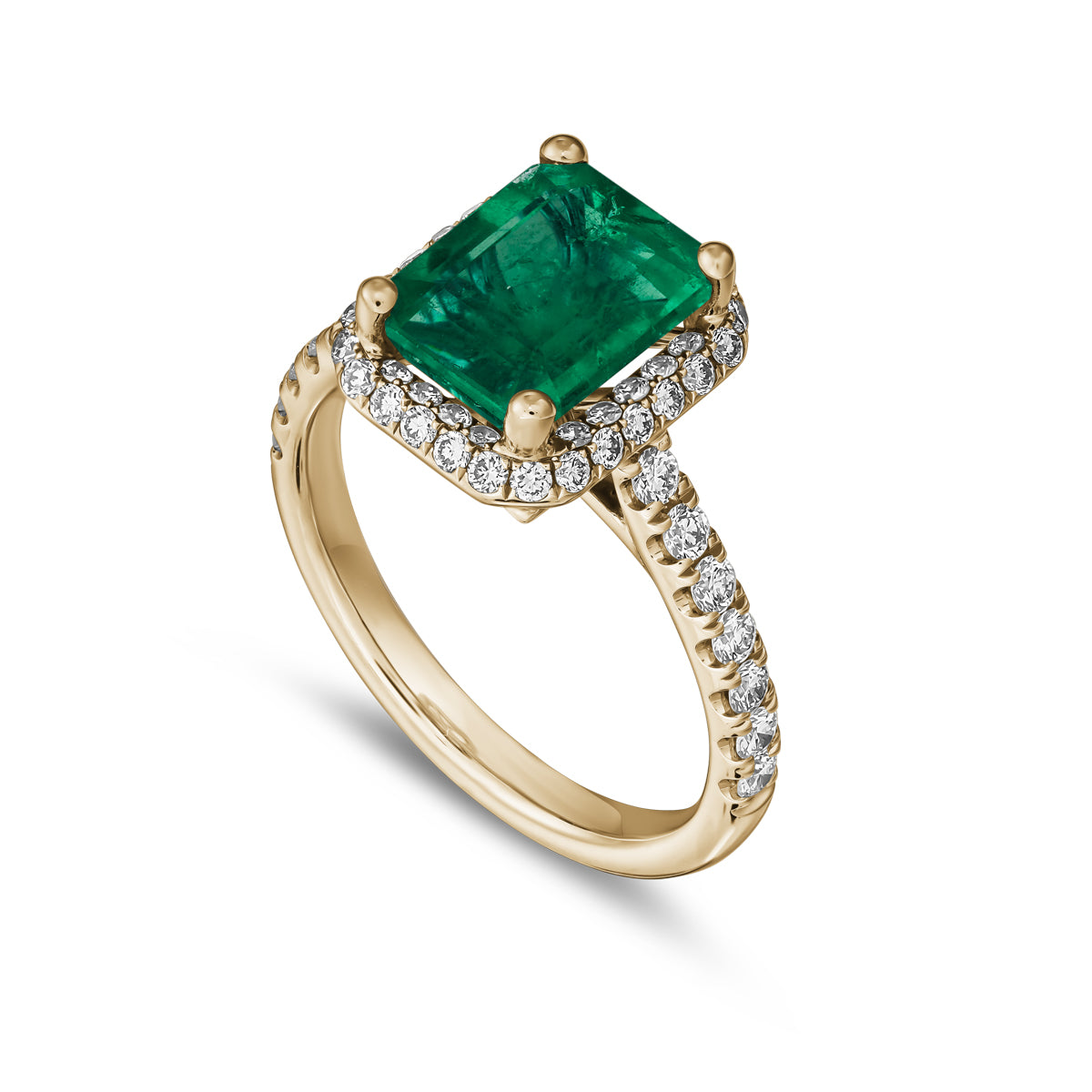 A two-tone gold ring featuring a radiant cut emerald gemstone with a halo of pave set diamonds around it designed by carati jewelry montreal canada 18 k 14 k