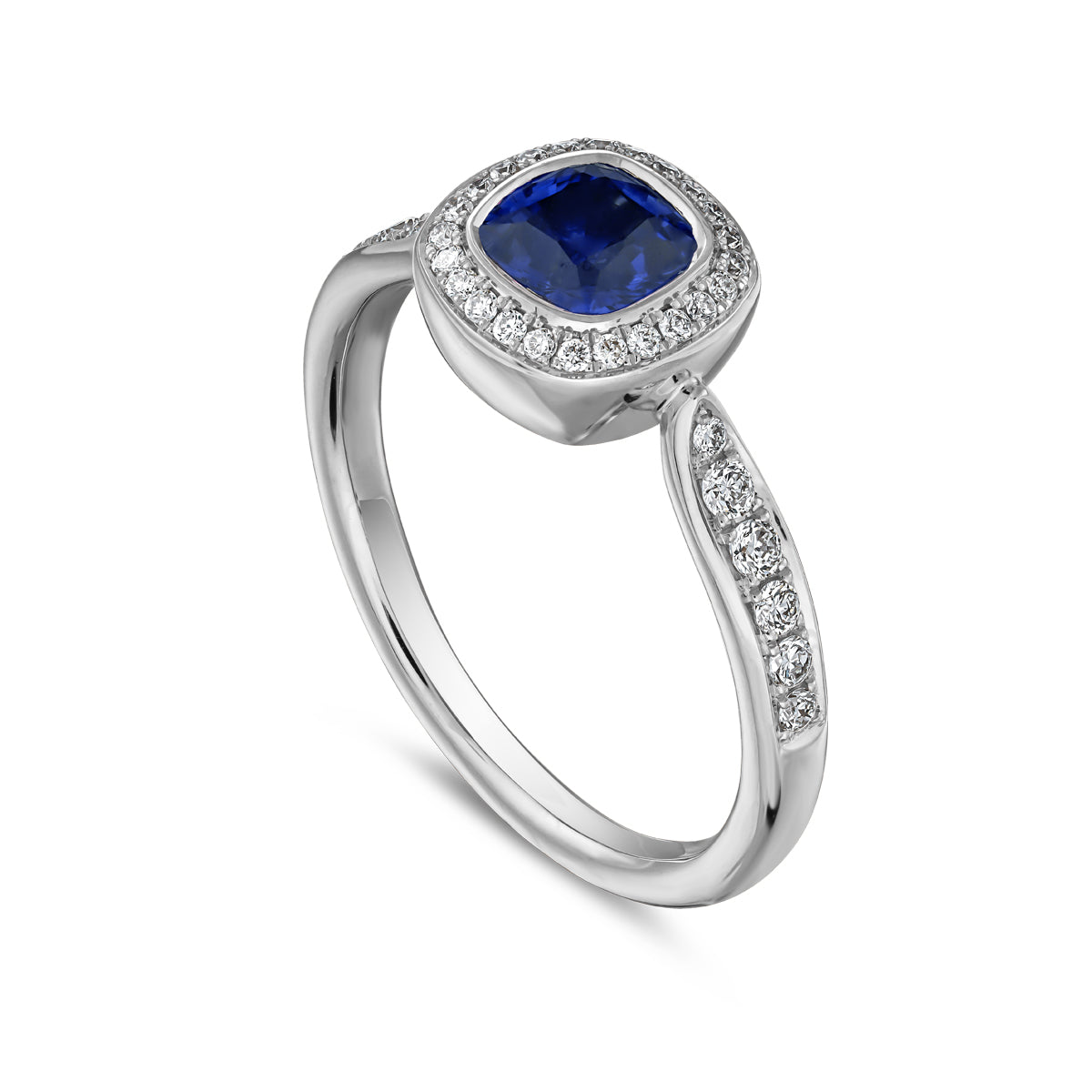 Royal harmony ring with royal blue sapphire cushion surrounded by pave diamonds and on the shank designed by carati jewelry in montreal canada 14k 18 k