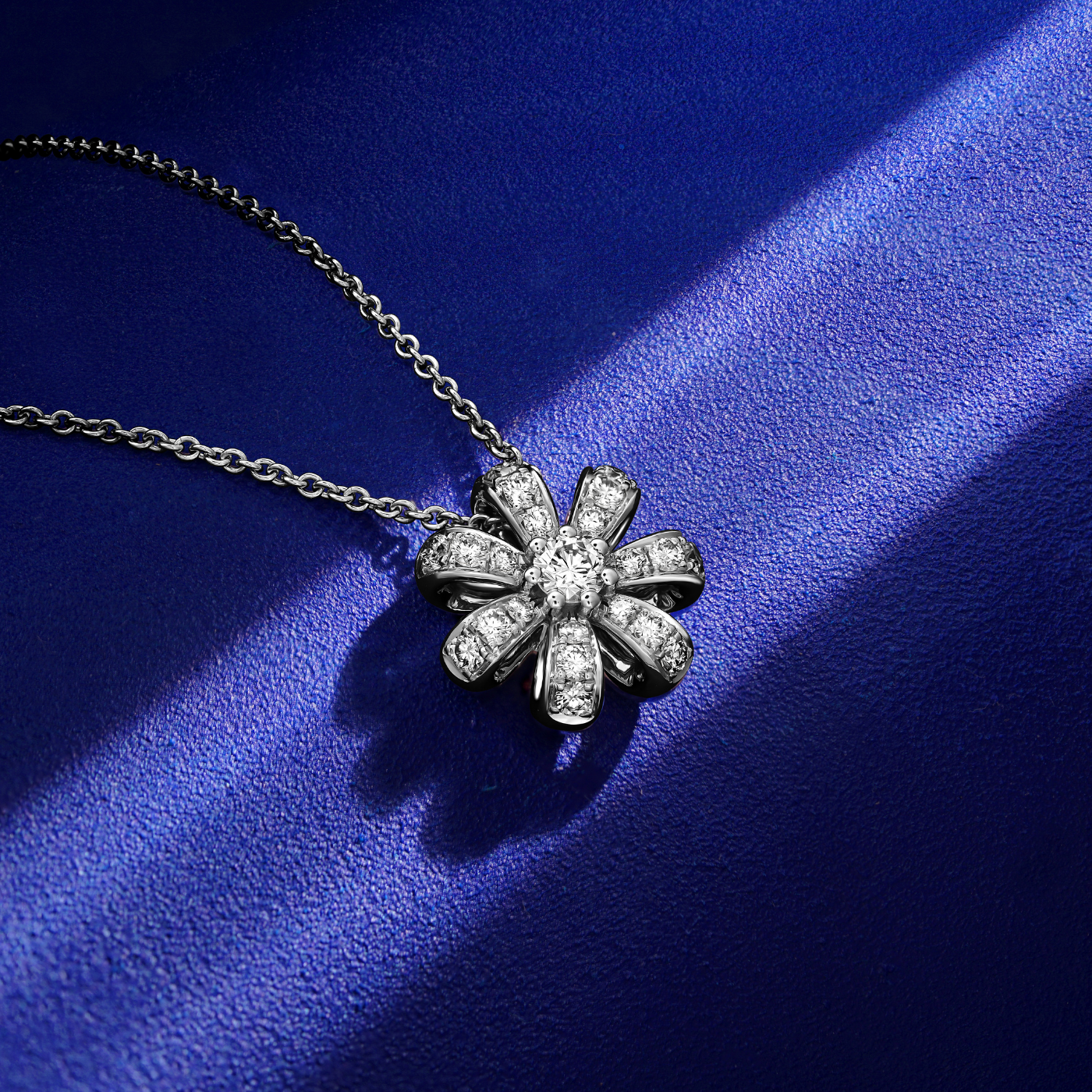Fiora pendant set in pave diamonds  a Sparkling diamond in the middle is iconic design from carati jewelry in montreal canada in 18k 14 k in blue backround and zoomed