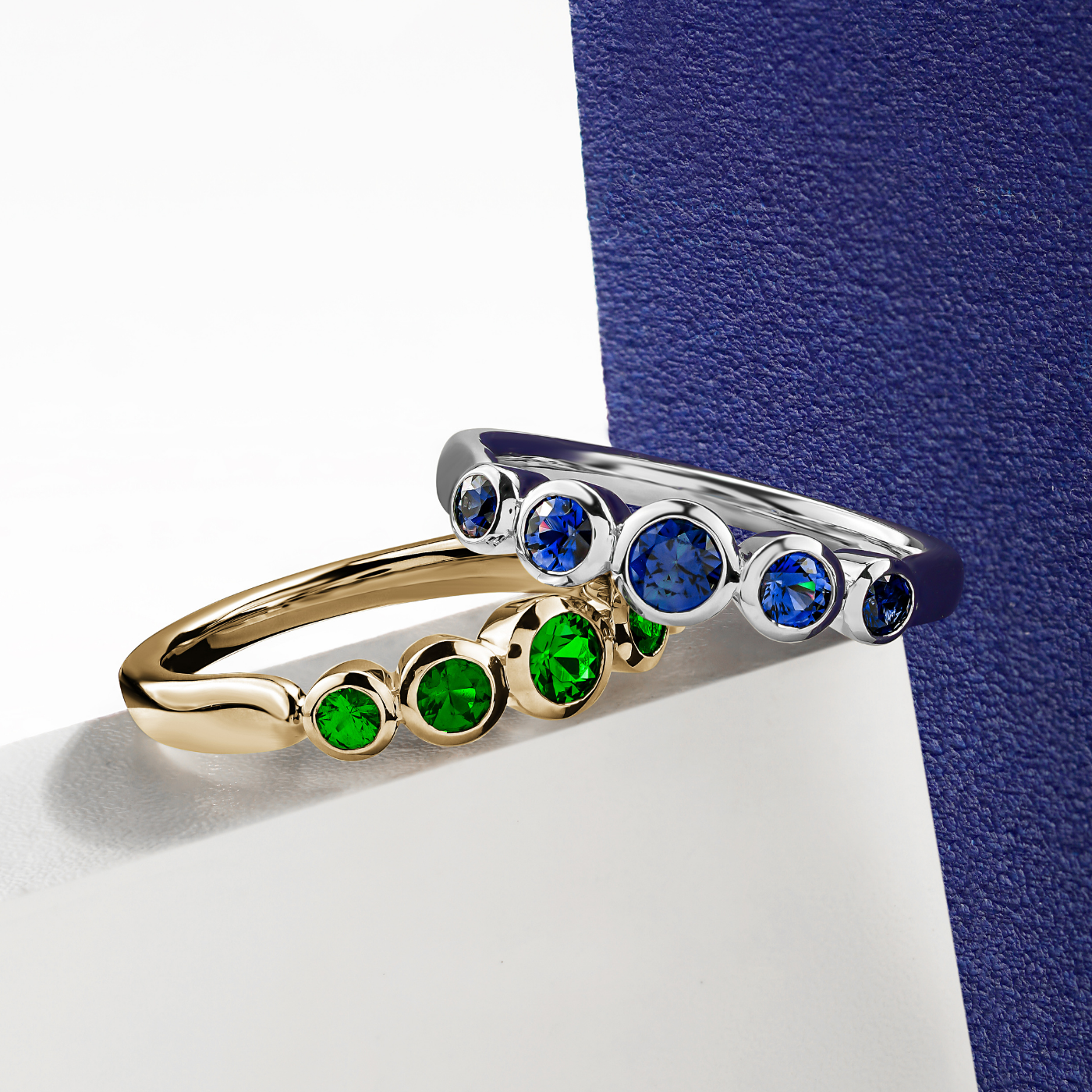 Aria ring with 5 bezels set in Tsavorites designed by carati jewelry montreal canada 18k 14 k  with blue backround and white zoom
