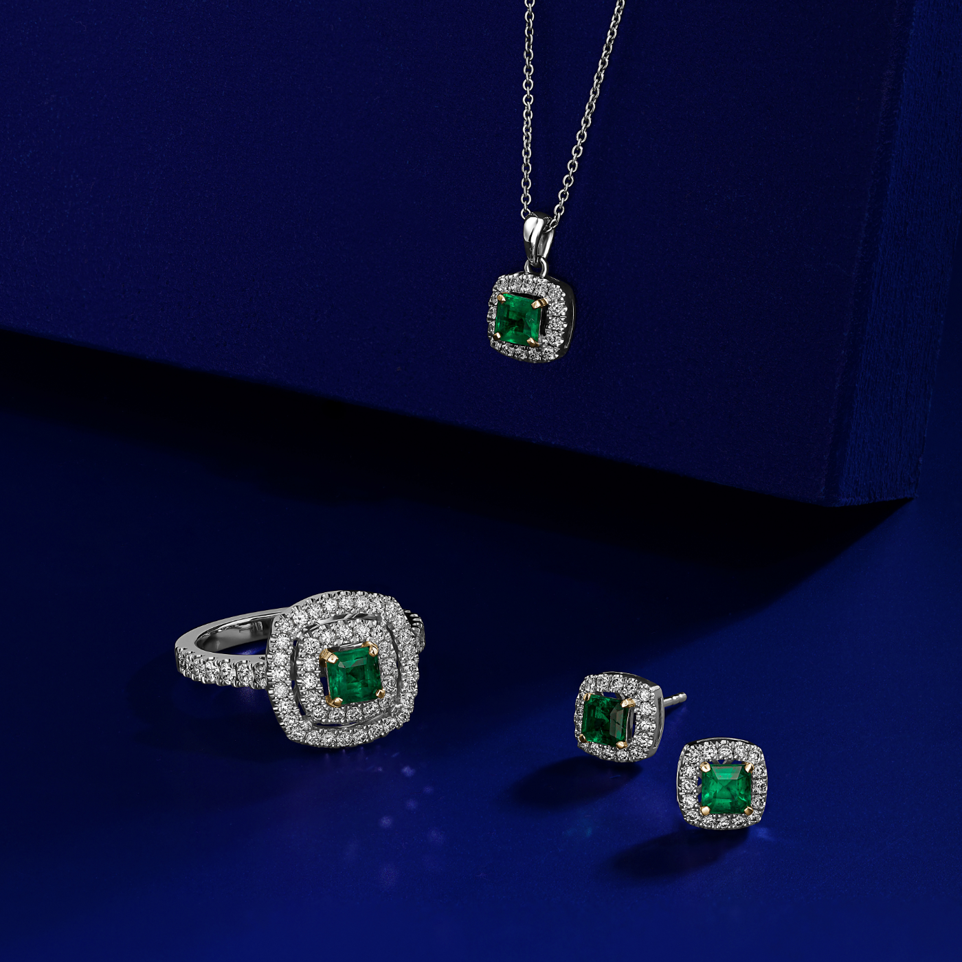 in blue backround all the set,A square emerald set in two tone in a double halo ring with a setted shank designed by carati jewelry in 14k 18 k in vs diamonds