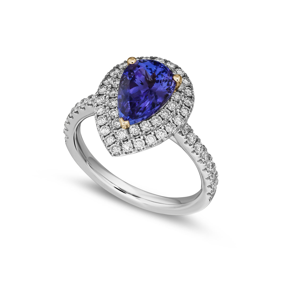 A two row two tone halo ring centered with a pear-shaped tanzanite stone and surrounded by smaller diamonds set in a silver or white gold band from carati jewelry montreal canada