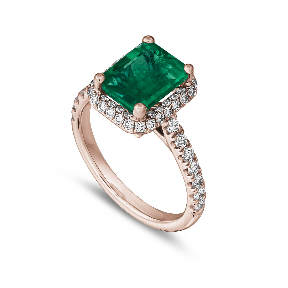 A two-tone gold ring featuring a radiant cut emerald gemstone with a halo of pave set diamonds around it designed by carati jewelry montreal canada 18 k 14 k